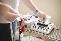 Mittelteil der Physiotherapeutin justiert Elektronadeleinheit in der Klinik — Stockfoto