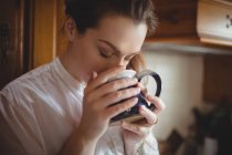 Woman having coffee in kitchen at home — Stock Photo