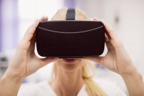 Médica usando fone de ouvido de realidade virtual na clínica — Fotografia de Stock