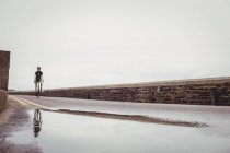 Male athlete riding bicycle on country road — Stock Photo