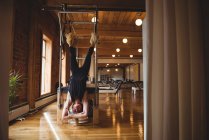 Femme adulte moyenne pratiquant le pilates dans un studio de fitness — Photo de stock