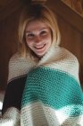 Портрет красивой женщины, завернутой в шерстяное одеяло в спальне дома — стоковое фото