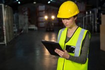 Porträt einer schönen jungen Frau mit Tablet-PC in der Fabrik — Stockfoto