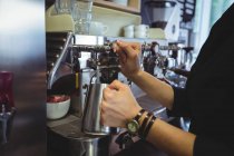 Camarera usando la máquina de café en la cafetería - foto de stock