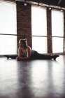 Jeune danseuse effectuant des exercices d'étirement dans un studio de danse — Photo de stock