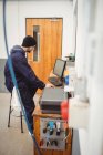 Mechanic working on personal computer in repair garage — Stock Photo
