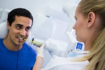 Dentista femenina tomando rayos X de dientes de paciente en la clínica - foto de stock