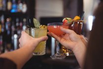 Close-up de amigos brindar com cerveja e copos de cocktail no bar — Fotografia de Stock
