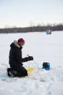 Рыбак на льду рыбачит в снежном ландшафте и деревьях — стоковое фото