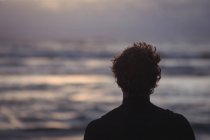Silhouette of a surfer by sea at dusk — Stock Photo