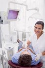 Portrait of female dentist examining patient in dental clinic — Stock Photo