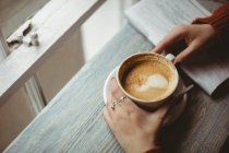 Nahaufnahme weiblicher Hände mit Kaffeetasse — Stockfoto