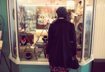 Frau sieht Schmucktheke im Supermarkt von hinten an — Stockfoto
