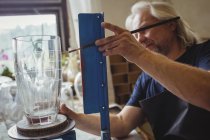 Soffiatore di vetro che lavora su una vetreria presso una fabbrica di soffiaggio del vetro — Foto stock