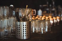 Primo piano di bicchieri vuoti e strumenti da bar disposti su scaffale in un bar — Foto stock