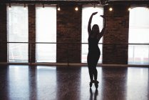 Молодая женщина, исполняющая современный танец в танцевальной студии — стоковое фото