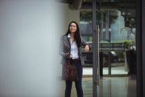 Portrait of businesswoman standing at office entrance — Stock Photo