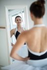 Bailarina de pé na frente do espelho no estúdio de balé — Fotografia de Stock