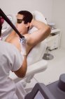 Medico che esegue la depilazione laser sulla pelle ascella del paziente maschile in clinica — Foto stock