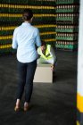Rear view of female manager looking at male worker working at warehouse — Stock Photo