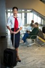 Personnel féminin avec sac trolley debout au terminal de l'aéroport — Photo de stock