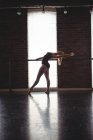 Bailarina praticando movimento de balé no barre no estúdio de balé — Fotografia de Stock