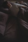 Visão traseira do homem dormindo em sua cama no quarto em casa — Fotografia de Stock