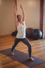 Femme en bonne santé pratiquant le yoga en studio de fitness — Photo de stock