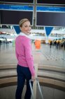Retrato de mulher viajante de pé com bagagem na área de espera no aeroporto — Fotografia de Stock