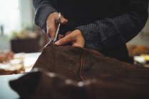 Sección media de la artesana de corte de cuero en el taller - foto de stock