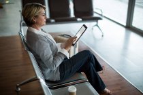 Geschäftsfrau nutzt digitales Tablet im Wartebereich am Flughafen-Terminal — Stockfoto