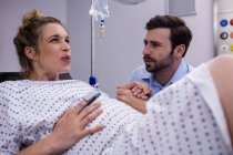 Мужчина утешает беременную женщину во время родов в больнице — стоковое фото