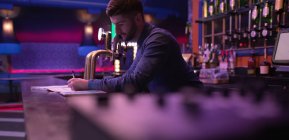 Barkeeper hält Schallplatten am Tresen in Bar — Stockfoto