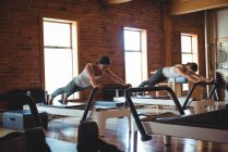 Femmes pratiquant pilates sur les réformateurs dans le studio de fitness — Photo de stock