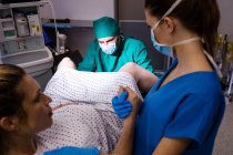 Ärzteteam untersucht Schwangere während der Entbindung im Operationssaal — Stockfoto