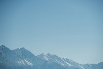 Vista tranquilla della catena montuosa innevata contro il cielo blu — Foto stock