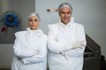 Portrait of two butchers standing with arms folded — Stock Photo