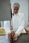 Carnicero cortar carne con la máquina de corte de carne en la fábrica de carne - foto de stock