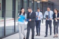 Group of confident business people walking outside office building — Stock Photo