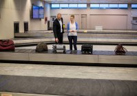 Paar wartet im Gepäckausgabebereich am Flughafenterminal auf sein Gepäck — Stockfoto