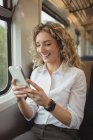 Веселая деловая женщина, отправляющая смс со смартфона во время путешествия — стоковое фото