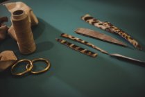 Кожаные детали и катушка для ниток на столе в мастерской — стоковое фото