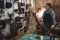 Lächelnde Handwerkerinnen im Umgang miteinander in der Werkstatt — Stockfoto