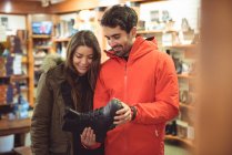 Счастливая пара выбирает обувь вместе в магазине — стоковое фото