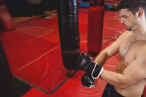 Boxer wearing grappling gloves in fitness studio — Stock Photo