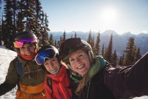 Porträt dreier Skifahrerinnen, die gemeinsam auf schneebedeckten Bergen stehen — Stockfoto