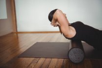 Mulher exercitando com rolo de espuma no estúdio de fitness — Fotografia de Stock