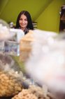 Portrait of beautiful woman standing in turkish sweets shop — Stock Photo