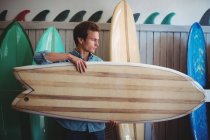 Mann wählt Surfbrett in einem Geschäft aus — Stockfoto