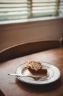 Plate of pastry on wooden table in living room at home — Stock Photo